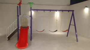 Outdoor metal swing set with three kids’ swings installed for a children’s play area in Saudi Arabia.
