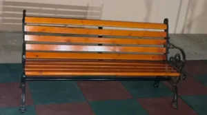 Outdoor wooden bench with black metal frame for parks and garden seating areas.