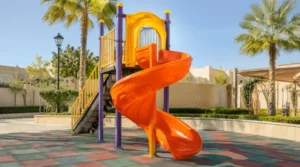 Spiral outdoor kids slide in Saudi Arabia with colorful playground frame and rubber safety flooring.