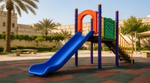 Straight outdoor kids slide in Saudi Arabia with blue slide, platform, ladder, and rubber safety flooring.