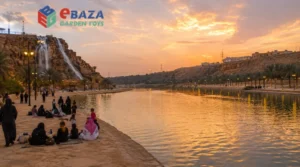 Wadi Namar in Riyadh with its lake, rocky surroundings, man-made waterfall, and families relaxing near the water at sunset.