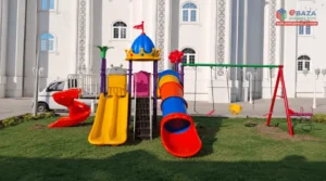 Private playground in Makkah with a play tower, straight, spiral and tunnel slides, and a separate swing set, installed by Ebaza Gardens.