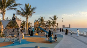 Jeddah Waterfront playground with children playing, Saudi families walking by the sea, palm trees, and Corniche views at sunset.