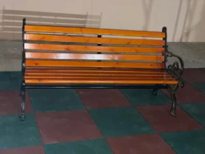 Outdoor garden bench with wooden seat and metal frame placed on rubber flooring for parks, compounds, schools, and play areas in Saudi Arabia