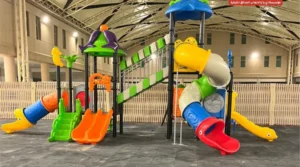 School playground with colorful tube slides, double slides, and elevated play structure.