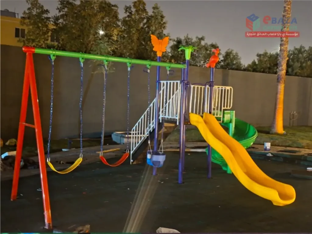 Playground project with yellow straight slide, green spiral slide, swings, raised play tower, safety railings, and rubber flooring.