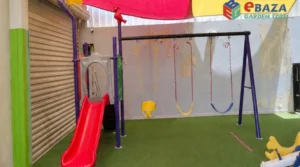 Outdoor children’s swing set with toddler bucket seat and standard swing seats beside a red playground slide.