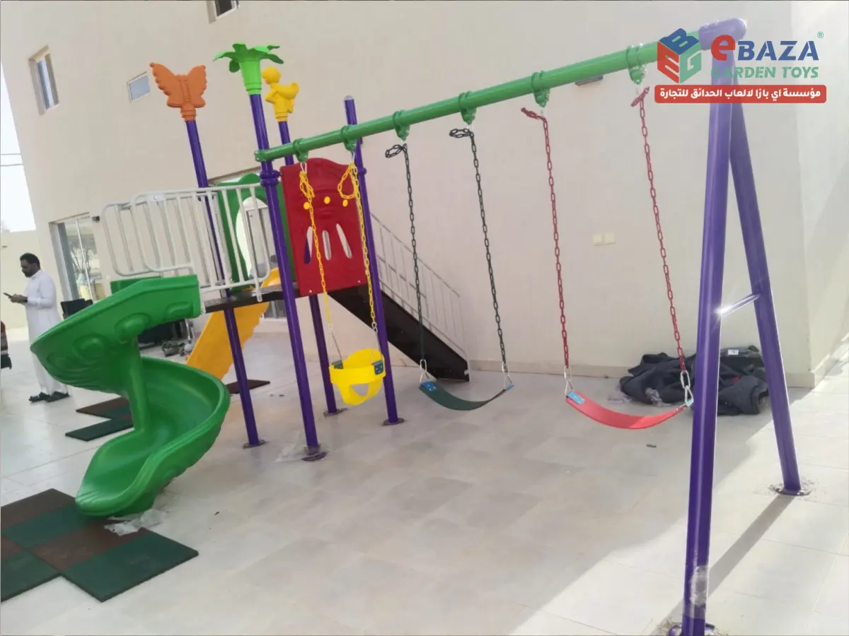 Completed outdoor villa playground installation in Buraidah, Saudi Arabia featuring a multi-play tower, spiral slide, straight slide, and four-seat swing set by Ebaza Gardens.