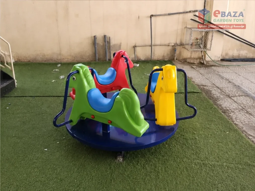 Animal-themed children’s merry-go-round in Dammam–Al Khobar with colorful seats and handrails on artificial grass.