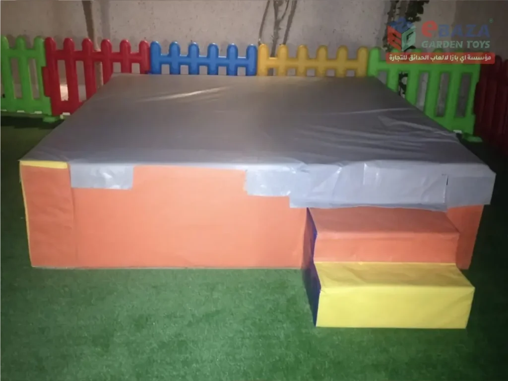Large padded soft-play platform with foam steps in a children’s play area.