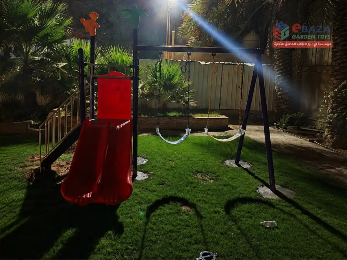 Residential playground installation in Riyadh with double slide and two-seat swing set.