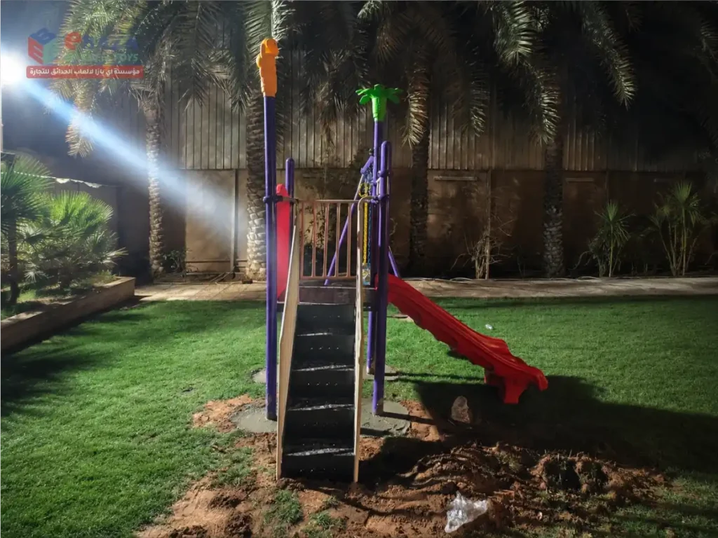Home garden playground in Riyadh with stairs, raised platform, and red slide.