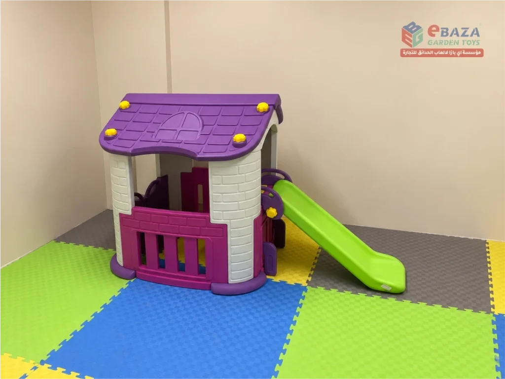 Toddler playhouse with green slide and foam flooring at Alfanar indoor playground in Riyadh.