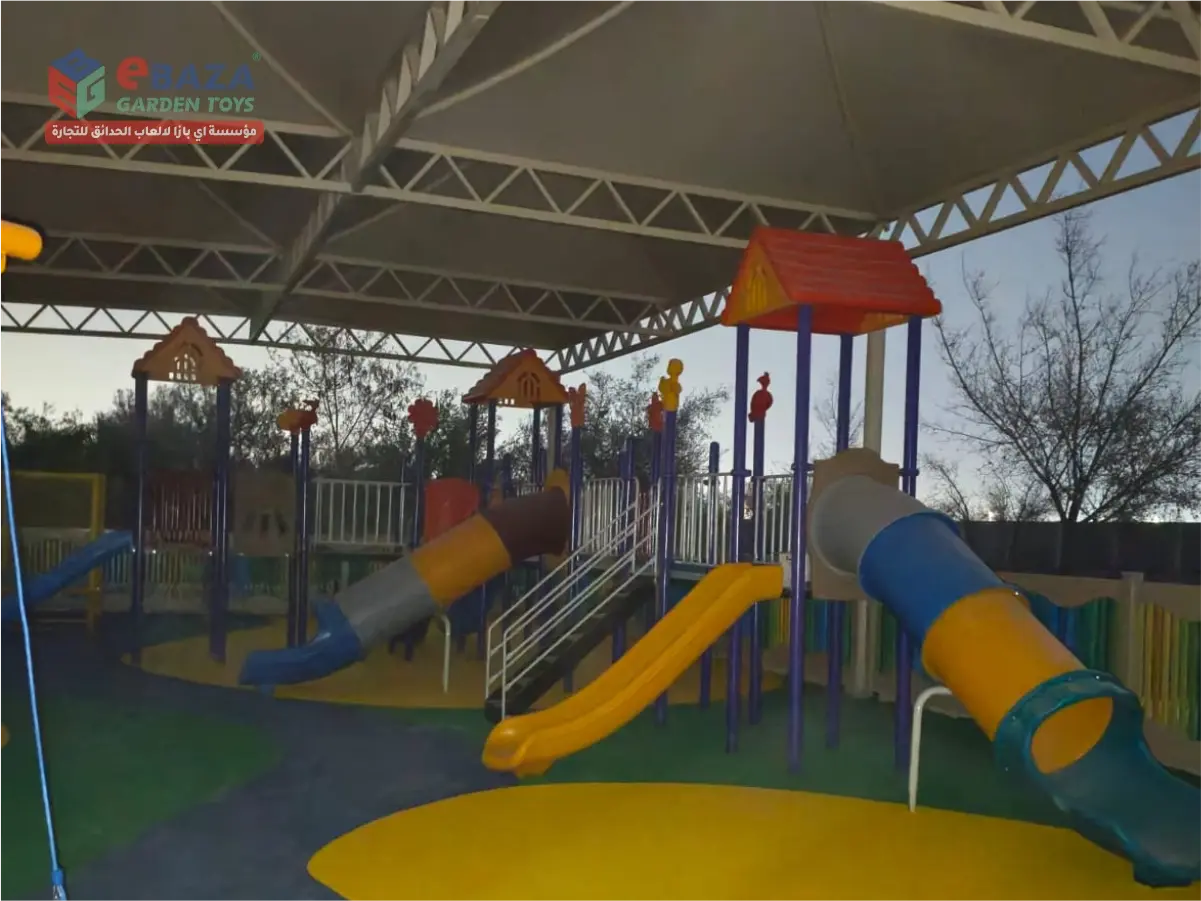 Outdoor playground installation in Al Kharj farmhouse with play towers, straight slides, tube slides, stairs, guardrails and shaded play area.