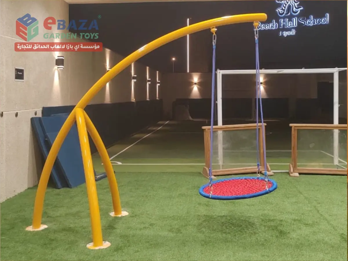 Circular basket swing with curved yellow metal frame installed at Beech Hall School Riyadh playground.