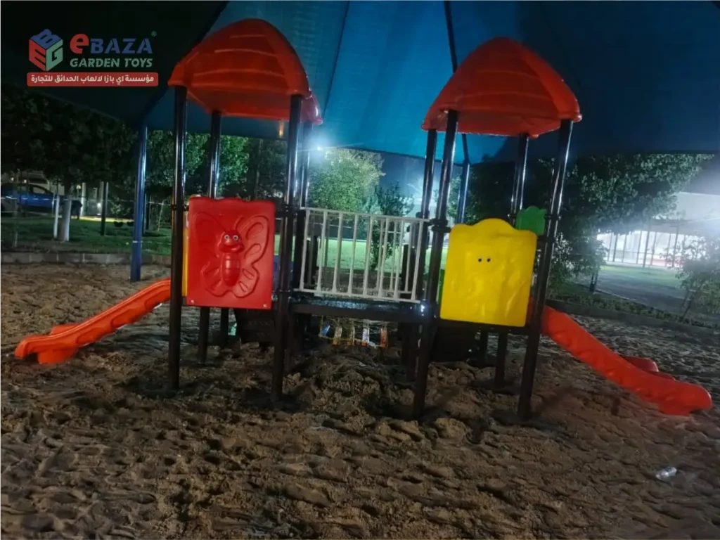 Outdoor playground equipment in Ras Tanura at Saudi Aramco Najmah with two play towers, slides, activity panels and shaded play area.