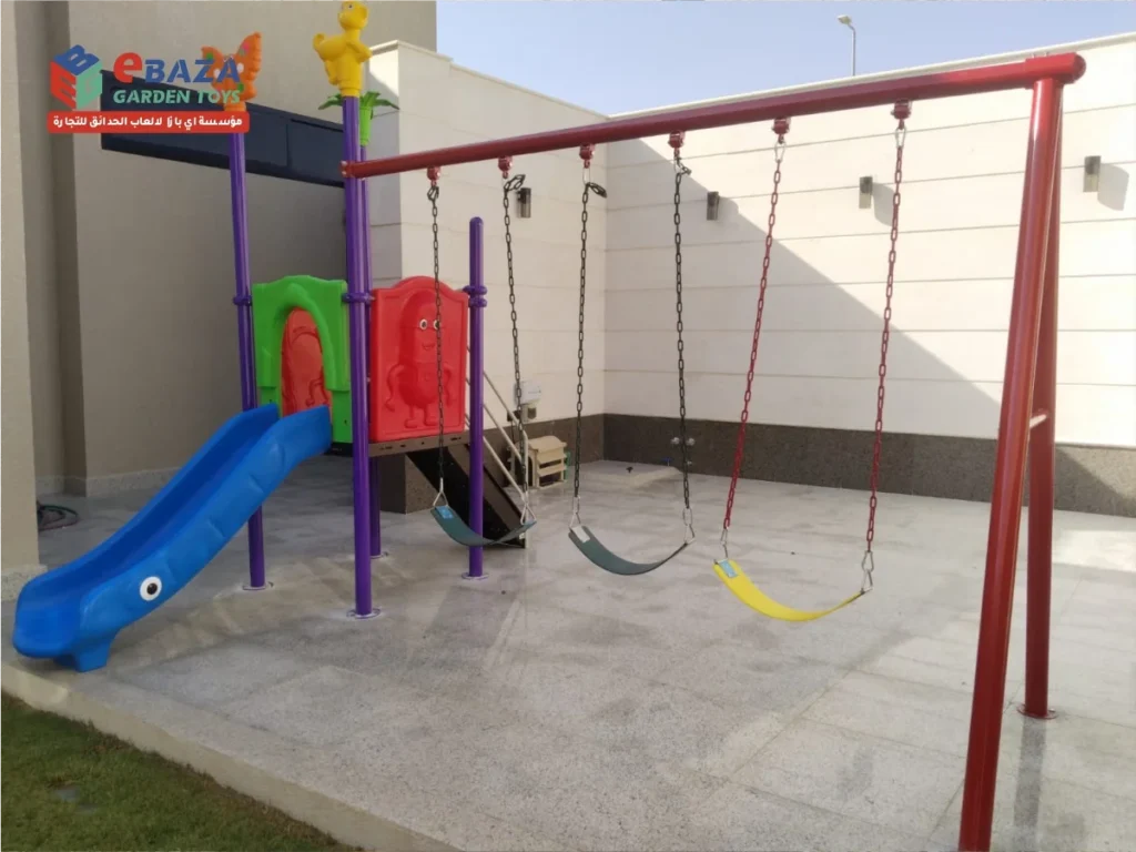 Home playground installation in Al Malaz, Riyadh with a play tower, blue slide and red three-seat swing set